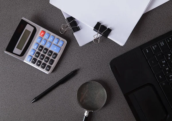 Bilgisayar, hesap makinesi, belgeler ve büyüteç, finansal raporlama için. İş ofisleri kavramı.
