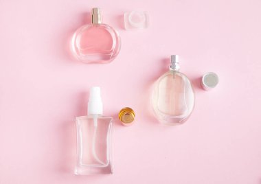 Güzel kadın parfümleri, soyutlanmış pembe arka planda.
