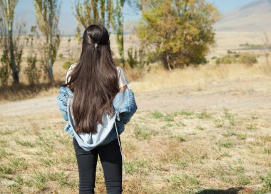 Genç kız yüksek dağlarda sonbaharın renklerine hayran..