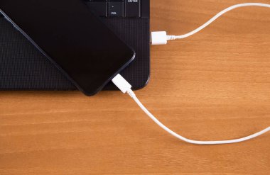 Ahşap arka plan izole şarj cihazı, akıllı telefon ve bilgisayar.