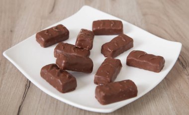 Tabakta lezzetli çikolata şekerlemeleri, ahşap arka plan..