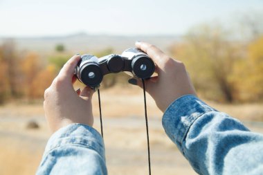 Dürbünlü genç kız yüksek dağlarda.