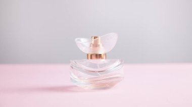 Pembe arka planda izole edilmiş güzel kadın parfümü..