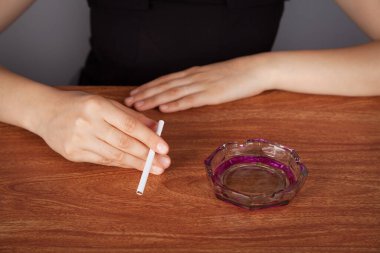 Elinde sigara tutan genç bir kadın..