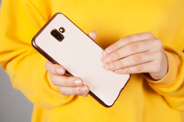 In a woman\'s hand a smartphone and beautiful case.
