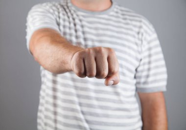 Gri arka planda kızgın adam yumruğu. 