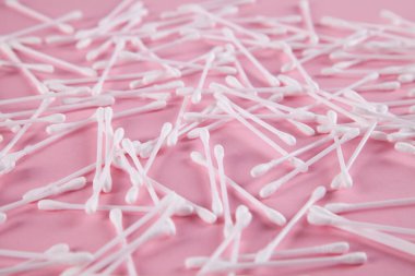 Pamuk kulak çubukları, pembe arka plan.