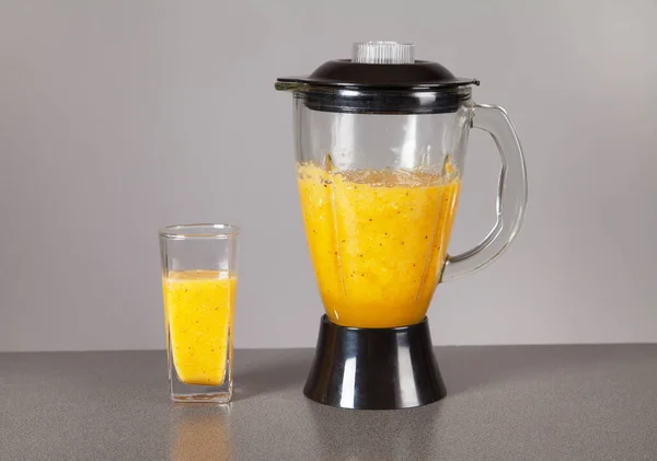 Fruit in a blender from which the juice is made. Juice in a glass.