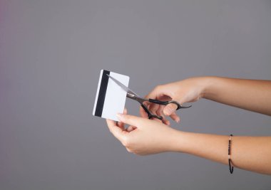 Kredi kartı kesen genç bir kadının elleri..