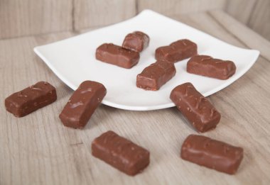 Tabakta lezzetli çikolata şekerlemeleri, ahşap arka plan..