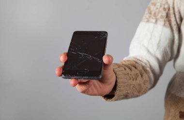 Kafkasyalı bir çocuğun elinde kırılmış bir telefon..