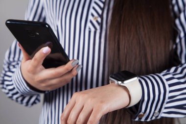 Genç kadın, akıllı saat, cep telefonu..