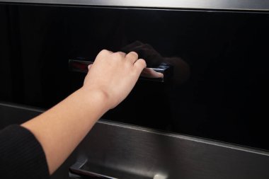 Kadın eli mutfak mobilyalarının kapısını açıyor..