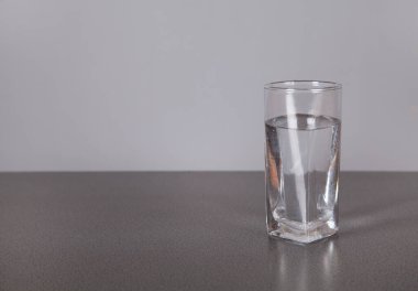 Gri arka planda, camlı su.