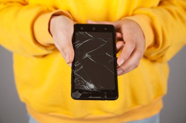 Kafkasyalı bir kadının elinde kırılmış bir telefon..