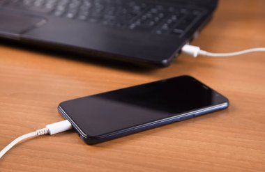 Ahşap arka plan izole şarj cihazı, akıllı telefon ve bilgisayar.
