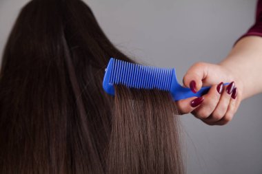 Profesyonel kuaför kadın, beyaz kadının saçını tarıyor..