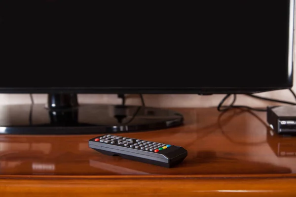 电视已经关机了 它坐落在一个现代化的客厅里 3D渲染 黑色电视机 遥控装置放在电视机旁边 — 图库照片