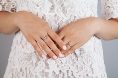 Bir sürü yüzük takan genç bir kadın. Beyaz elbiseli bir kadın..