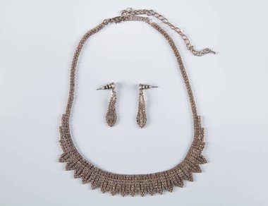 Kolye ve küpeler beyaz arka planda izole edilmiş. Moda kavramı.