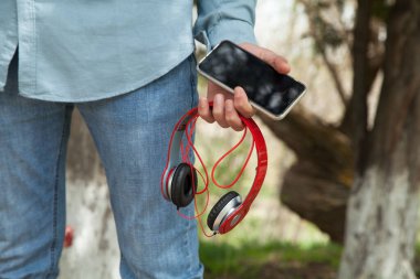 Adam tutma, modern kablosuz kulaklık ve akıllı telefon..