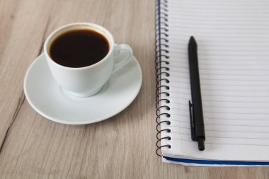 Not defteri, kalem ve kahve, ahşap arka plan..