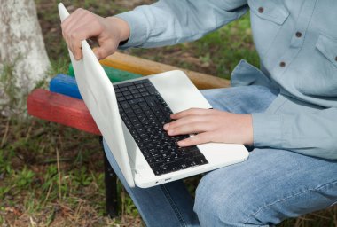 Adam dışarıda bilgisayarla çalışıyor..