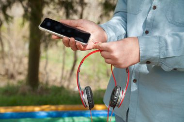 Adam tutma, modern kablosuz kulaklık ve akıllı telefon..