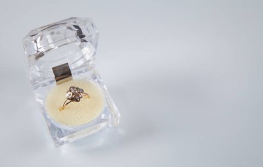 Beyaz arkaplanda yüzüğü olan kutu.