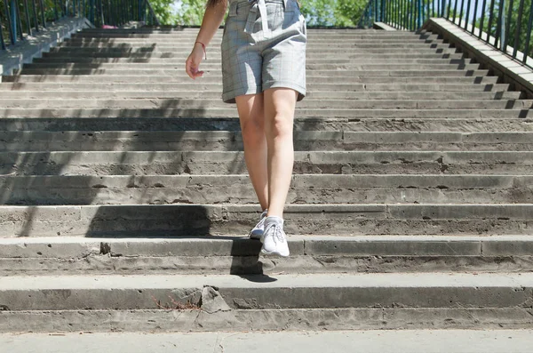 Beyaz kadın merdivenlerden iniyor.