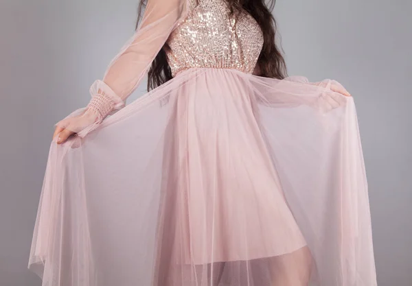 Κομψή Νεαρή Γυναίκα Ροζ Φόρεμα Κρατώντας Μια Φούστα Γκρι Φόντο — Φωτογραφία Αρχείου