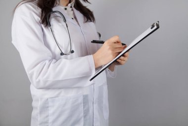 Gri arka planda panosu olan kadın doktor.. 