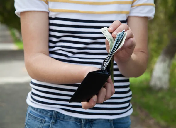Cüzdanı dolar olarak tutan adam. Açık hava..