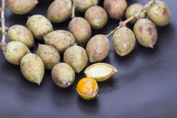 Ceylon oak fruit on black dish — Stock Photo, Image