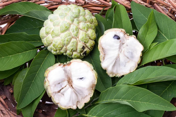 Hasır sepet içinde yapraklarla muhallebi elma