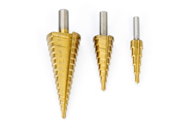 Üç adet titanyum kaplı basamaklı matkap uçları beyaz arka planda düzenlenmiş metal, plastik ve ahşap yüzeylerde delikler açmak için hassas metal aletler sergiliyor..