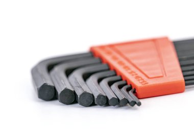 Turuncu bir tutacağa yerleştirilmiş altıgen anahtar setinin yakın plan görüntüsü, siyah çelikten yapılmış farklı boyutlarda, vidaları sıkmak veya gevşetmek için kullanılan L-biçimini gösterir