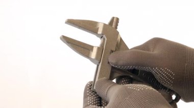 Eldivenli ellerde metalik bitiş, açık çene ve optimal işlevsellik ve tasarım için düz arkaplan karşı hassasiyet gösteren ayarlanabilir bir anahtar ve kalibre aracı