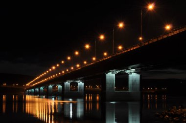 Kola Nehri 'nin karşısındaki Murmansk şehrindeki köprü. Gece görüşü. Aydınlatılmış köprü.