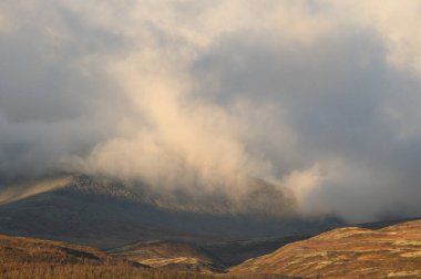 Khibiny Dağı 'nın kuzeyindeki Rus dağlarında sonbahar mevsimi. Khibiny dağları sonbaharda kalın beyaz bulutlarla. Görkemli dağlar tüm kayak ve turizm aşıkları için vazgeçilmez bir yerdir..