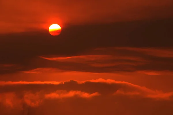 Sol rojo en llamas. Nublado paisaje al atardecer en lo alto de las nubes. Cielo rojo de finales de otoño. Una imagen fascinante en lo alto del cielo. Paisaje natural escena tranquila sol rojo y cielo rojo. — Foto de Stock