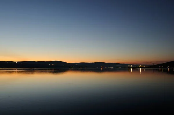 Βραδινή άποψη του Κόλπου Kola Murmansk είναι το κύριο λιμάνι στη βόρεια Ρωσία. Όμορφο ηλιοβασίλεμα με την αντανάκλαση των φώτων στον κόλπο. Όμορφο τοπίο στην πλευρά του Cape Abram. — Φωτογραφία Αρχείου