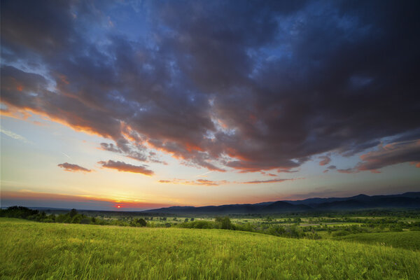 Драматический закат над зеленым полем