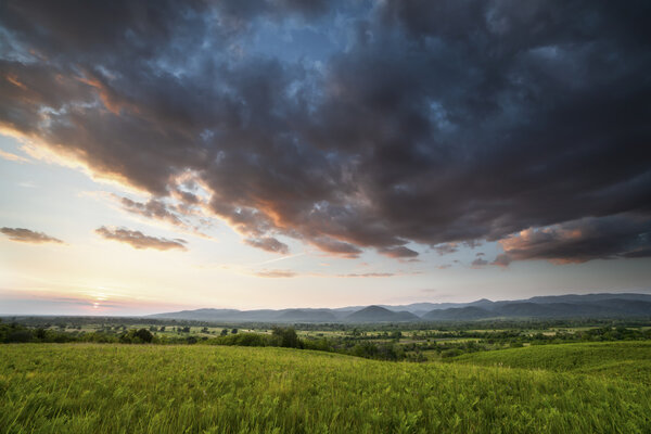 Драматический закат над зеленым полем