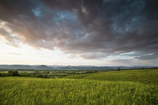 Драматический закат над зеленым полем
