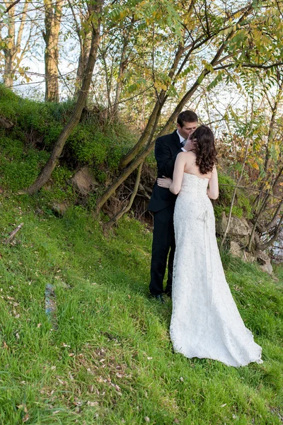 Elegante bruid en bruidegom poseren samen buitenshuis — Stockfoto