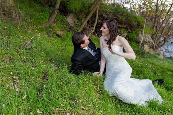 Elegante bruid en bruidegom poseren samen buitenshuis — Stockfoto