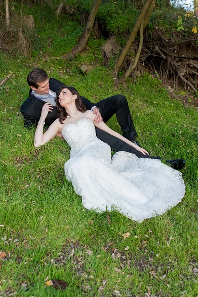 Elegante bruid en bruidegom poseren samen buitenshuis — Stockfoto