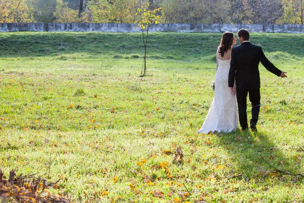 Elegante bruid en bruidegom poseren samen buitenshuis — Stockfoto