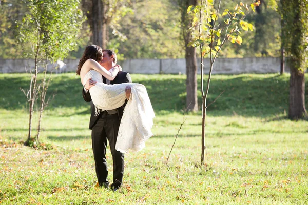 Elegante bruid en bruidegom poseren samen buitenshuis — Stockfoto